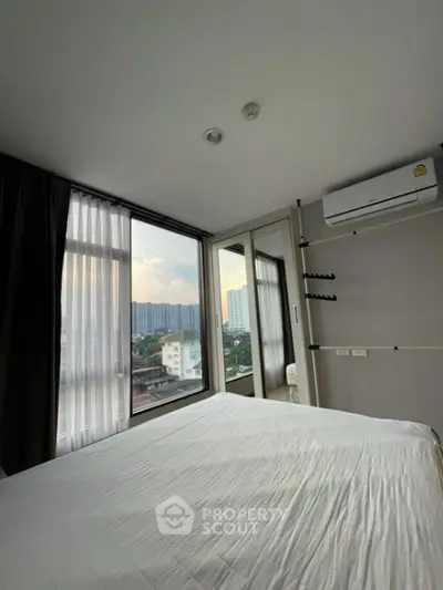 Modern bedroom with large windows offering city view and air conditioning unit.
