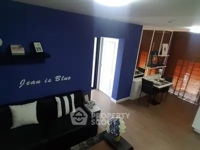 Stylish modern living room with blue accent wall and cozy seating area.