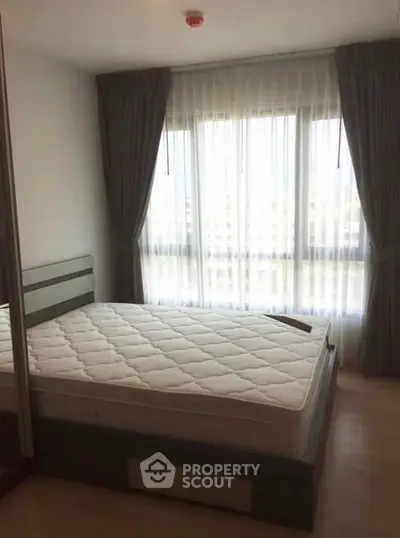 Cozy bedroom with large window and elegant curtains in modern apartment.