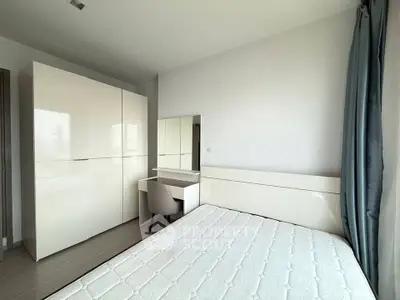 Modern bedroom with sleek white furniture and natural light