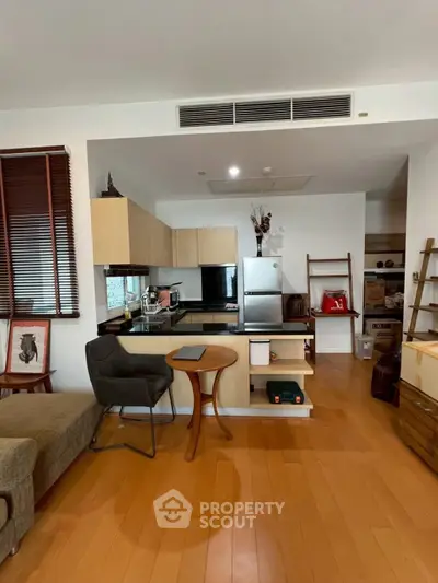 Modern open-layout kitchen with sleek appliances and cozy seating area, perfect for urban living.