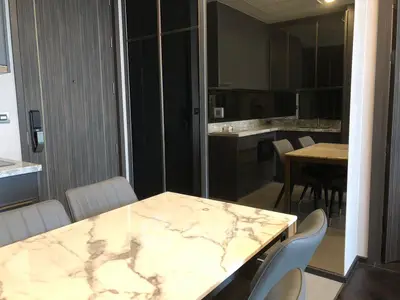 Modern dining area with marble table and sleek kitchen design