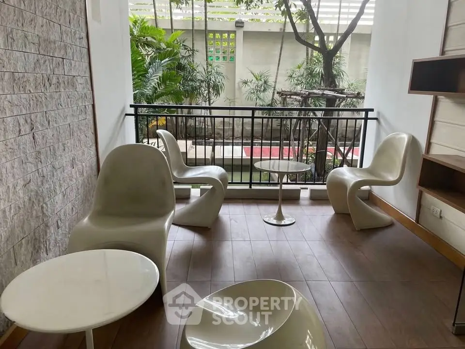 Chic outdoor seating area with modern chairs and lush garden view, perfect for relaxation and entertaining.