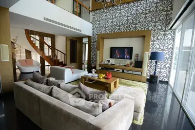 Luxurious living room with modern decor and elegant staircase in a spacious open-plan design.