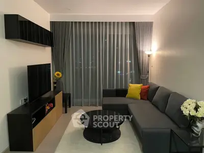 Modern living room with sleek furniture and large window, perfect for relaxation and entertainment.