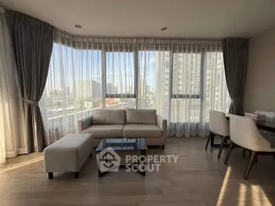 Spacious living room with panoramic city views and elegant furnishings.