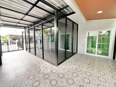 Spacious modern patio with glass enclosure and stylish tile flooring