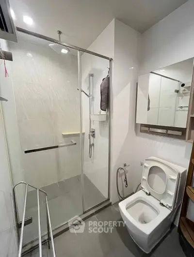 Modern bathroom with glass shower and sleek fixtures in a contemporary home.