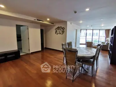 Spacious living room with dining area and wooden flooring in modern apartment.