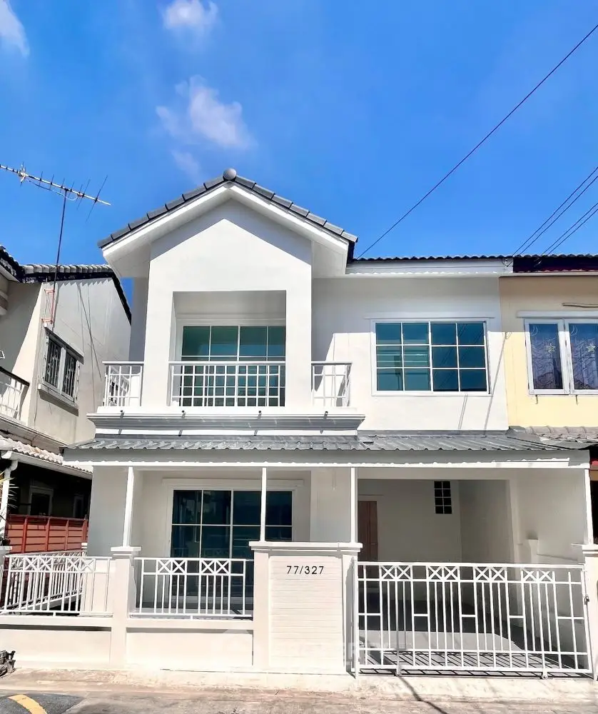 Charming two-story white house with balcony and modern design in a serene neighborhood.