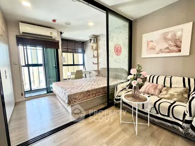 Modern studio apartment with stylish decor and glass partition in vibrant city location.