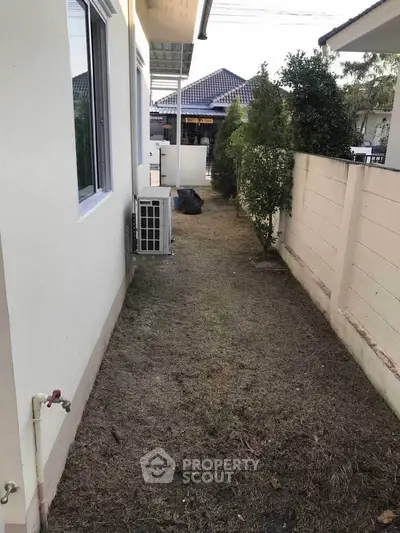 Narrow side yard with air conditioning unit and garden path