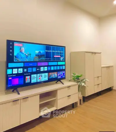Modern living room with sleek TV setup and stylish storage cabinets on wooden flooring.