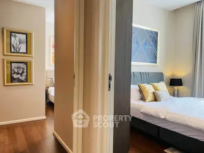 Modern bedroom with stylish decor and cozy ambiance, featuring elegant artwork and soft lighting.