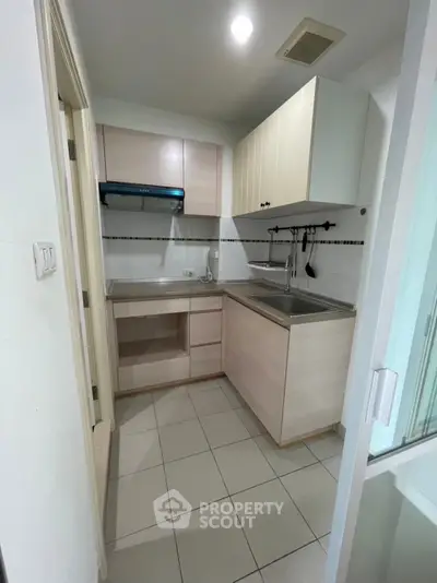 Compact kitchen with modern cabinetry and tiled flooring