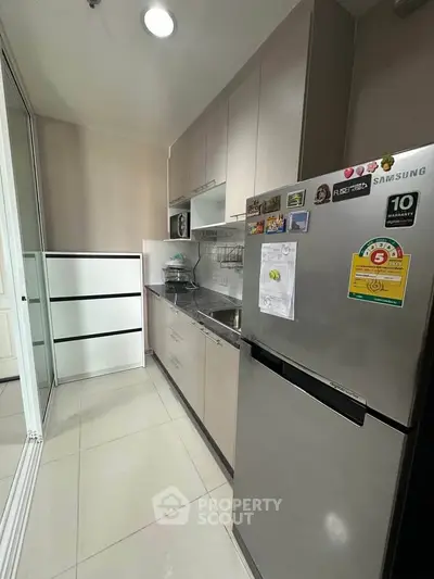 Modern kitchen with sleek cabinetry and stainless steel appliances in a compact layout.