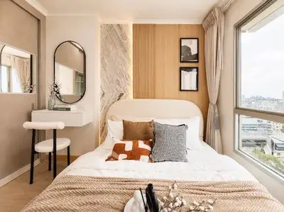 Stylish bedroom with modern decor and large window offering city views