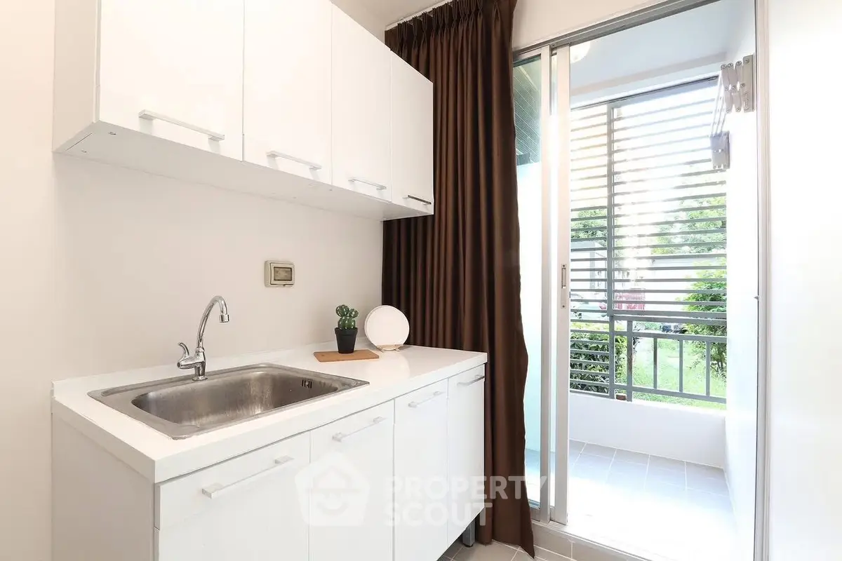 Modern kitchen with sleek cabinetry and balcony view