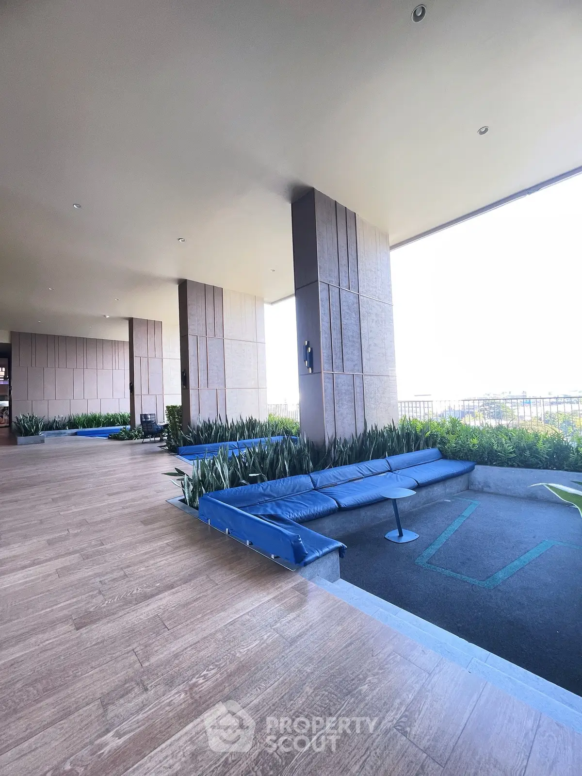 Spacious modern building entrance with sleek design and lush greenery, perfect for luxury living.