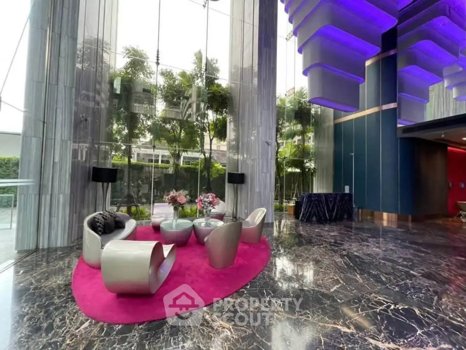 Luxurious modern lobby with marble floors and stylish seating area in high-end building.
