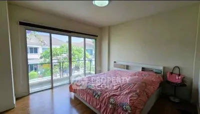 Spacious bedroom with large windows and balcony view in modern home