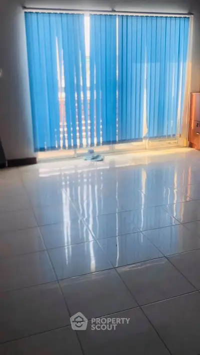 Spacious room with glossy tiled floor and blue vertical blinds.