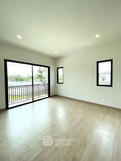 Spacious empty room with large windows and balcony access, perfect for customization.