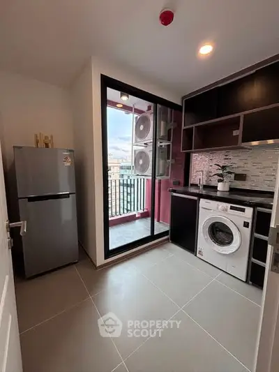 Modern kitchen with balcony view, featuring sleek appliances and stylish cabinetry.