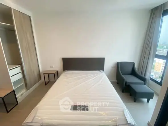 Modern bedroom with large window and stylish furniture in a high-rise apartment.