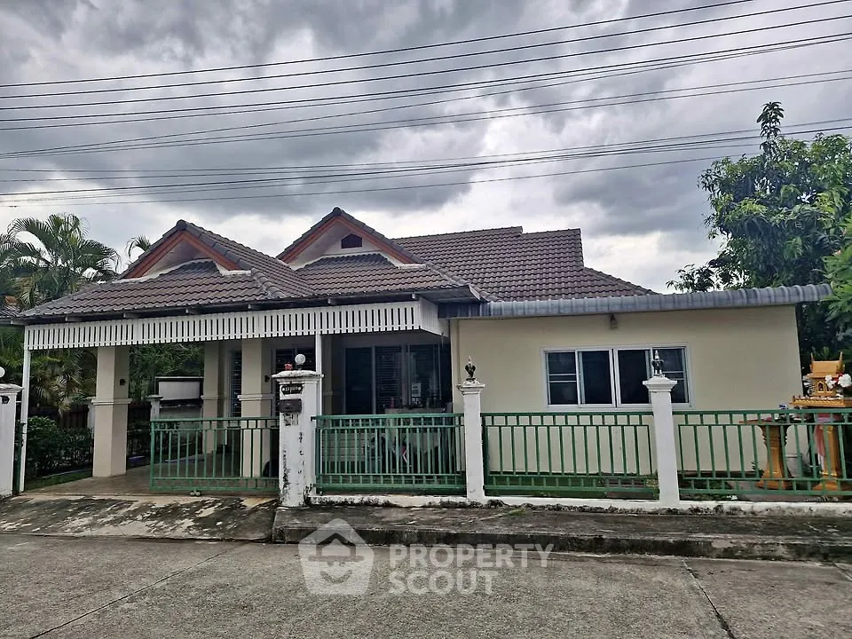 Charming single-story house with tiled roof and fenced yard, perfect for family living.