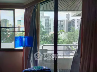 Spacious room with large windows offering a stunning city view and balcony access.