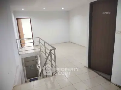 Spacious interior with staircase and restroom access, ideal for commercial or residential use.