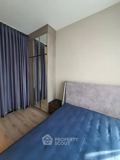 Modern bedroom with stylish mirrored wardrobe and elegant curtains