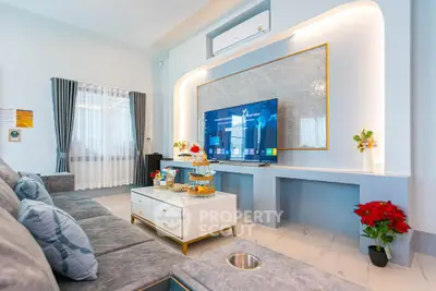 Luxurious living room with modern decor and large TV, perfect for relaxation and entertainment.