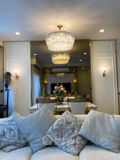 Luxurious living room with elegant chandelier and plush sofa, perfect for sophisticated gatherings.