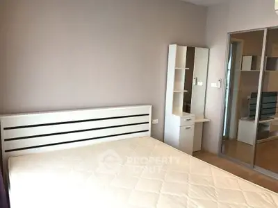 Modern bedroom with sleek white furniture and mirrored wardrobe doors