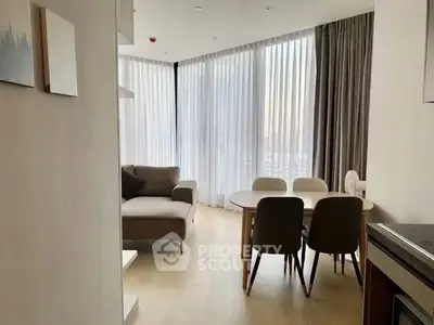 Modern living room with elegant dining area and large windows in a stylish apartment.