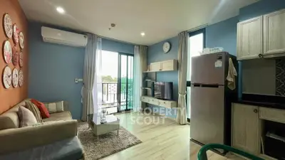 Modern living room with balcony access, stylish decor, and open kitchen layout in a cozy apartment.