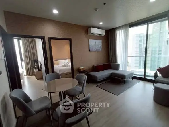 Modern living room with dining area and balcony view in high-rise apartment