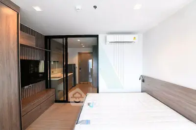 Modern bedroom with wooden accents and glass partition in a stylish apartment.