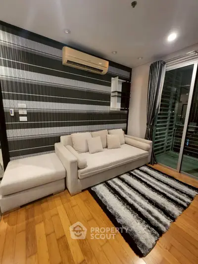 Modern living room with stylish sofa, air conditioning, and balcony access in a chic apartment.