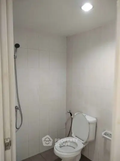 Compact bathroom with modern shower and toilet in minimalist design.