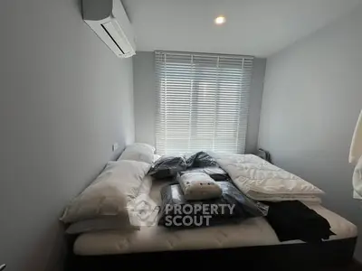 Cozy bedroom with modern air conditioning and natural light through blinds.