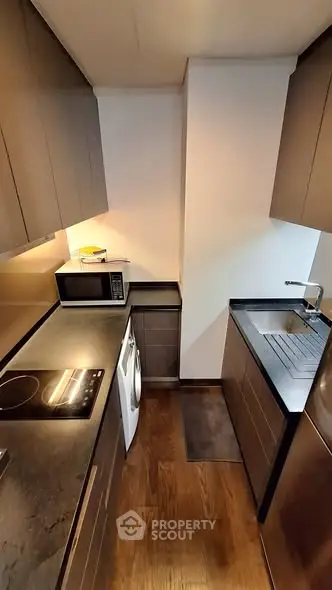 Modern compact kitchen with sleek cabinetry and built-in appliances