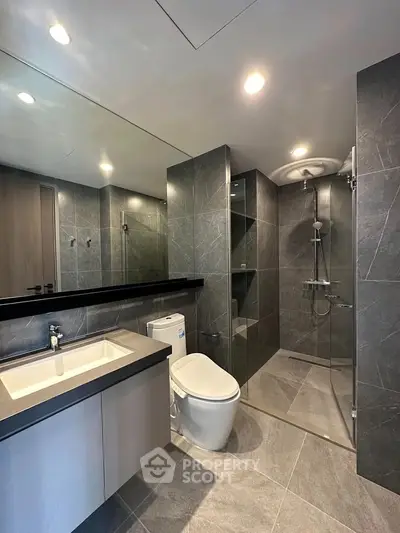 Modern bathroom with sleek design, featuring a glass shower enclosure and elegant fixtures.