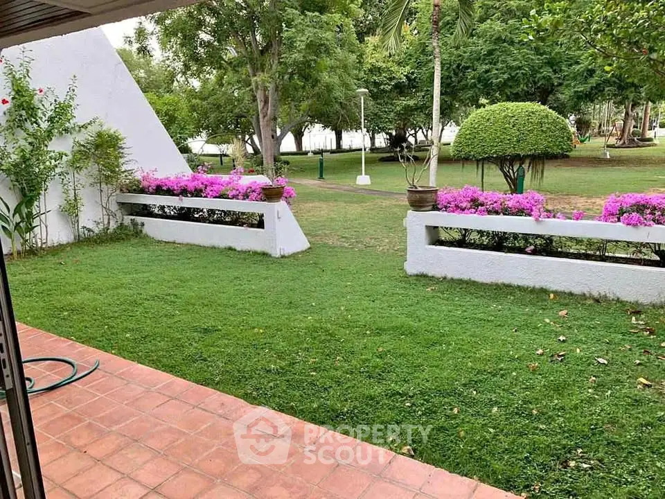 Charming garden view with lush greenery and vibrant flowers, perfect for outdoor relaxation.