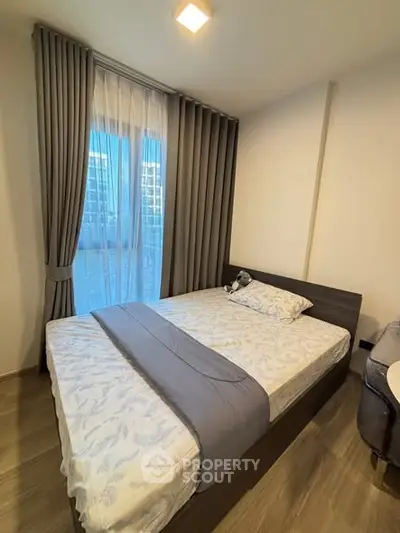 Modern bedroom with stylish decor and large window in a contemporary apartment.