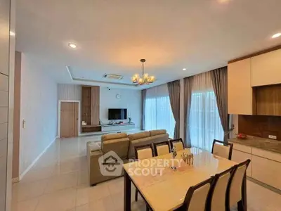 Spacious open-plan living and dining area with modern furnishings and large windows.