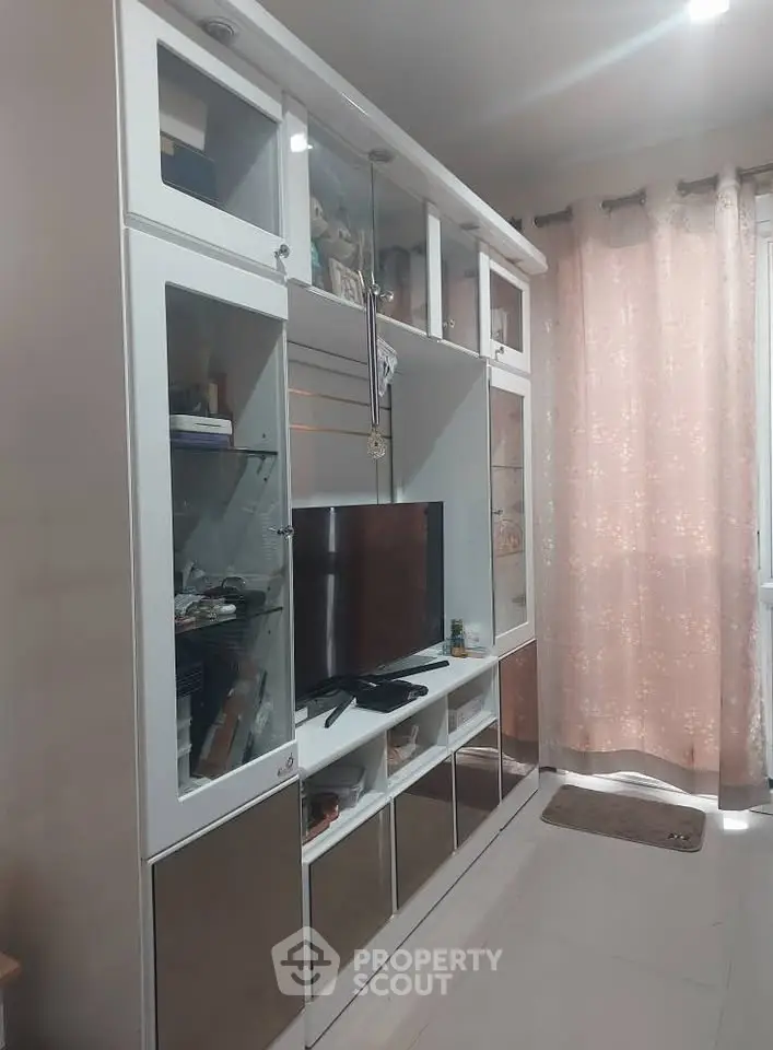 Modern living room with sleek white entertainment unit and soft pink curtains