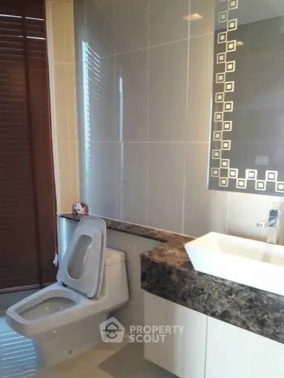 Modern bathroom with stylish sink and tiled walls in a luxury apartment.
